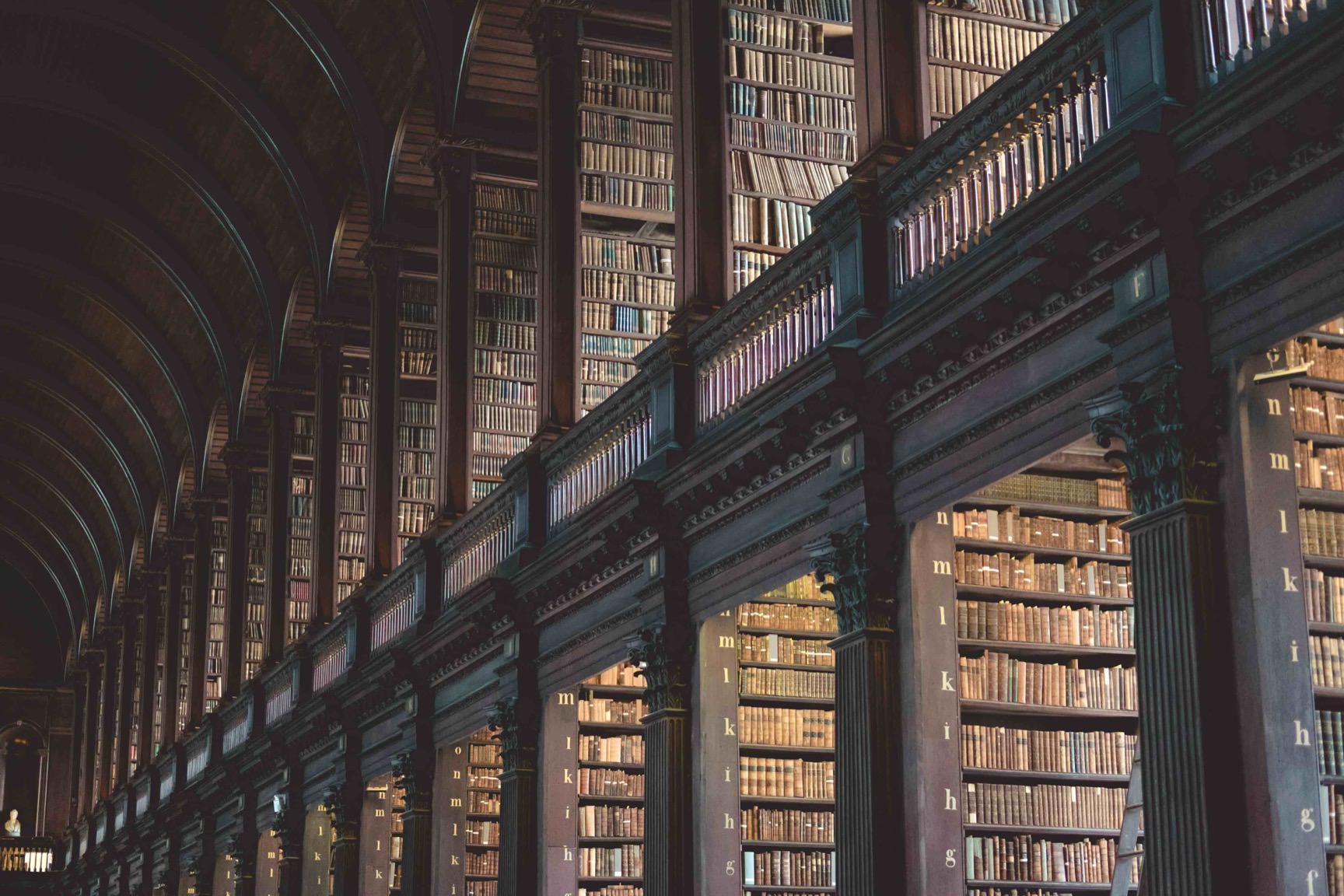 Large historic library interior with thousands of shelves full of books